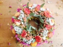 Snake weed wreath base with statice, strawflowers, culinary sage, roses and wild acorns found in Penasco.
