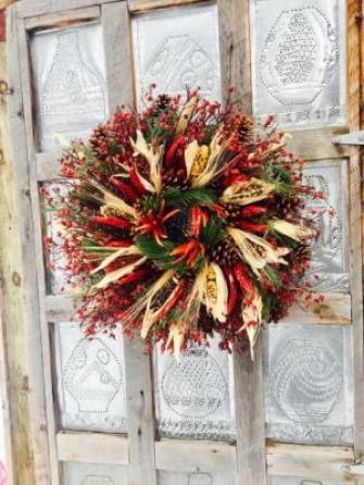Christmas wreath with wild rosehip base, pinecones, chile pequin, Indian corn, wheat, and pine boughs.